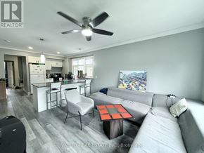 Windsor apartment for rent - A living room with a grey couch and a black and white rug.