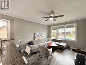 Windsor apartment for rent - A living room with a grey couch, a coffee table, and a ceiling fan.