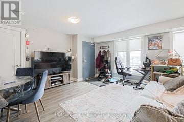 Toronto (Yorkdale-Glen Park) townhouse for rent - A living room with a blue chair and a cluttered bed.
