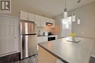London South (South F) apartment for rent - A kitchen with a stainless steel refrigerator and a countertop with a vase of flowers on it.