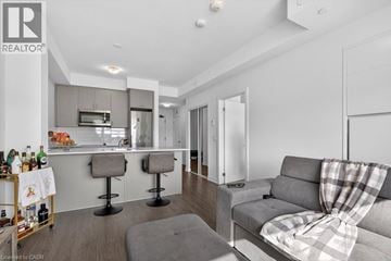 Hamilton condo for rent - A modern living room with a grey couch and a bar area.
