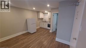 Kitchener apartment for rent - A kitchen area with a refrigerator, sink, and oven.