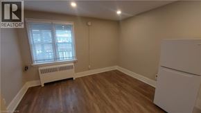 Kitchener apartment for rent - A room with a white refrigerator and a window with blinds.
