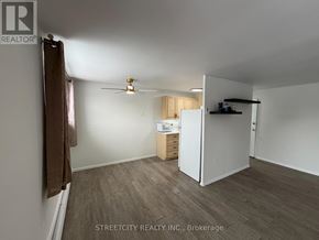 London East (East H) condo for rent - A room with a ceiling fan and a small kitchenette.