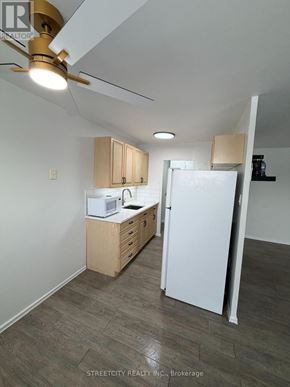 London East (East H) condo for rent - A kitchen with white appliances and wooden cabinets.