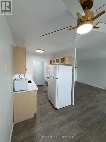 London East (East H) condo for rent - A kitchen with a refrigerator, microwave, and oven is being set up.