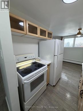 London East (East H) condo for rent - A kitchen with a white oven and refrigerator.