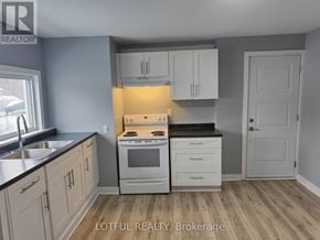 Elizabethtown-Kitley fourplex for rent - A kitchen with white cabinets and a black countertop.
