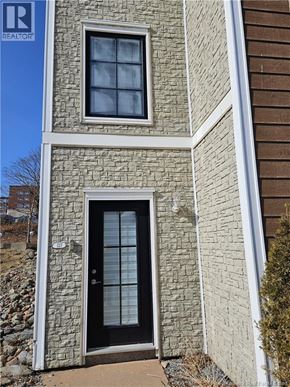 Saint John condo for rent - A stone house with a black door and a window.