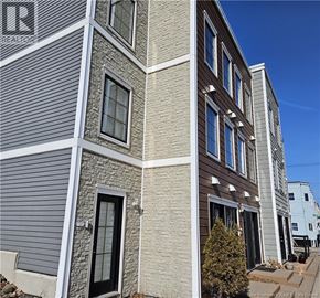 Saint John condo for rent - A building with a grey facade and a sign that says REALTOR.