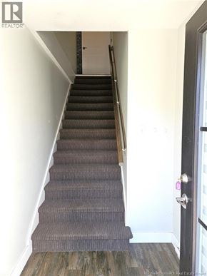 Saint John condo for rent - A staircase with a carpeted runner and wooden handrail.