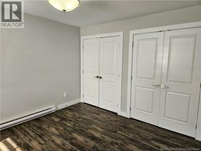 Saint John condo for rent - A room with two white doors and a wooden floor.