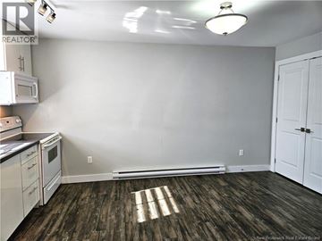 Saint John condo for rent - A kitchen with white cabinets and a microwave.