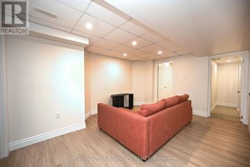 Mississauga (Churchill Meadows) apartment for rent - A living room with a red couch and a television.