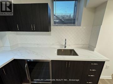 Markham (Wismer) townhouse for rent - A kitchen with black cabinets and a marble countertop.