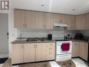 Brampton (Bram East) apartment for rent - A kitchen with wooden cabinets and a white stove top oven.