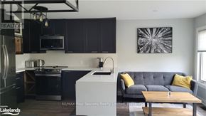 Blue Mountains townhouse for rent - A modern kitchen with a grey sofa and yellow pillows.
