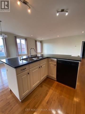 Quinte West (Murray Ward) apartment for rent - A kitchen with white cabinets and black countertops.