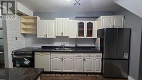 Hamilton (Vincent) townhouse for rent - A modern kitchen with a bar area and a clock on the wall.