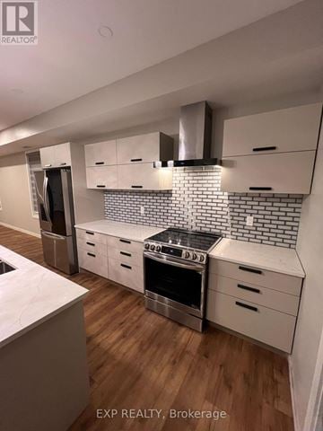 Ottawa fourplex for rent - A kitchen with a stove top oven and a refrigerator.