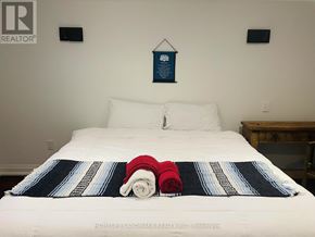 Niagara Falls (Chippawa) apartment for rent - A bed with a white sheet and a blue and white striped blanket with a red and white striped pillow on it.