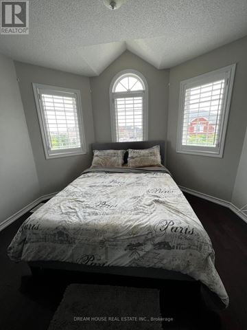 Brampton (Bram East) apartment for rent - A bedroom with a bed in the center and two windows on the wall.