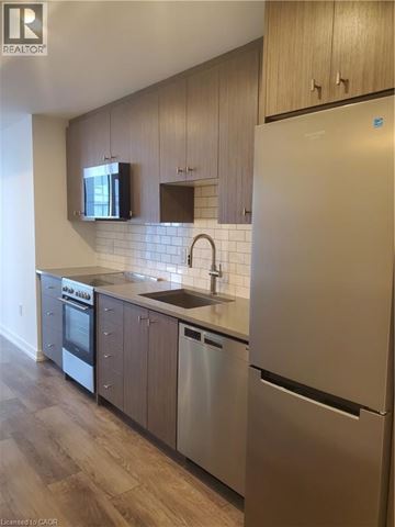 Kitchener condo for rent - A kitchen with a white refrigerator, stainless steel dishwasher and oven.