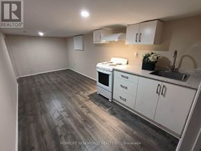 Toronto (Briar Hill-Belgravia) apartment for rent - A kitchen with white cabinets and a wooden floor.