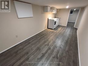 Toronto (Briar Hill-Belgravia) apartment for rent - A room with wood flooring and a white appliance.