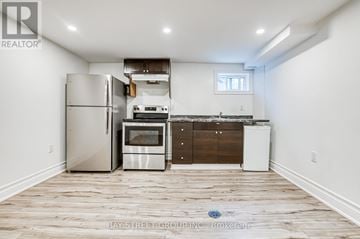 Newmarket (Bristol-London) apartment for rent - A kitchen with a refrigerator, oven, and dishwasher in a room with wooden flooring.