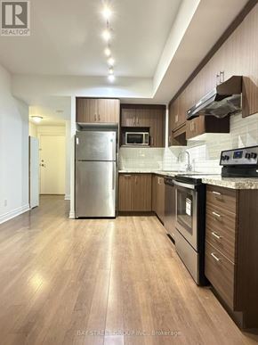 Markham (Unionville) condo for rent - A modern kitchen with wooden cabinets and stainless steel appliances.