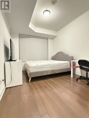Markham (Unionville) condo for rent - A bedroom with a bed, chair, and television.