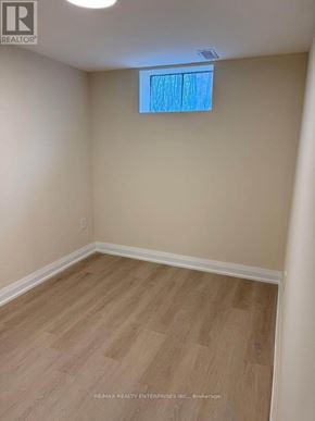 St. Catharines (Carlton/Bunting) duplex for rent - A room with a window and wooden flooring.