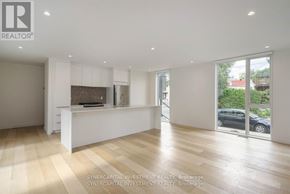 Ottawa townhouse for rent - A spacious, well-lit room with wooden flooring and white walls.
