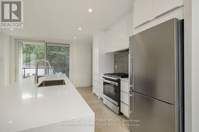Ottawa townhouse for rent - A modern kitchen with a refrigerator, sink, and oven.