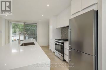 Ottawa townhouse for rent - A modern kitchen with a refrigerator, sink, and oven.