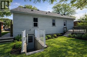 Kitchener apartment for rent - A white house with a grey roof and a small front porch.