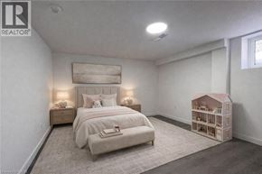 Kitchener apartment for rent - A bedroom with a bed, nightstands, and a dollhouse.