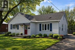 Kitchener apartment for rent - A white house with a red door and a striped awning.