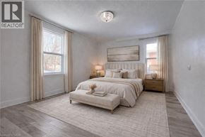 Kitchener apartment for rent - A bedroom with a large bed and a window with curtains.