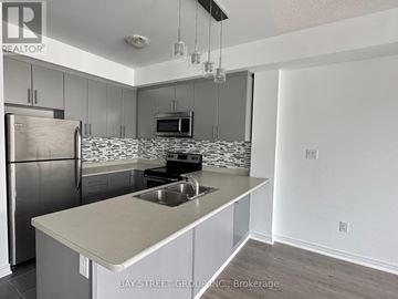 Oakville (Ro River Oaks) townhouse for rent - A kitchen with a refrigerator, microwave, and stove top oven.