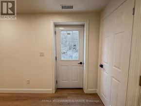 Ajax (South East) apartment for rent - A white door in a room with a window showing a snowy scene outside.