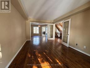 Aurora (Aurora Highlands) apartment for rent - A spacious room with wooden floors and a staircase in the background.