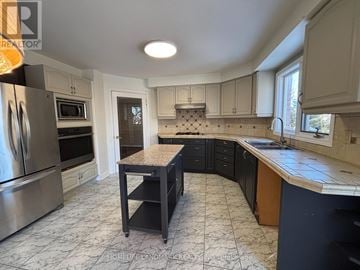 Aurora (Aurora Highlands) apartment for rent - A kitchen with a tile floor and a table in the middle.