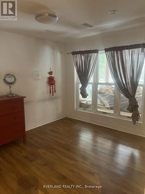 Markham (Unionville) apartment for rent - A room with a wooden floor and a window with curtains.