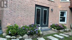 Markham (Unionville) apartment for rent - A brick house with a black door and a window with flowers in front.