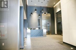 Toronto (Church-Yonge Corridor) condo for rent - A hallway with a glass wall on the left and a reception desk in the middle.