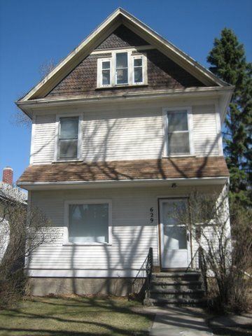 Saskatoon apartment for rent - A two-story house with a white exterior and a brown roof.