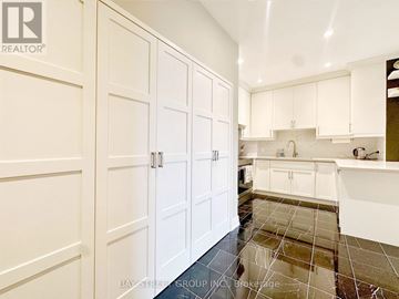 Toronto (Annex) condo for rent - A kitchen with white cabinets and a tile floor.