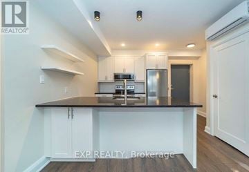 Ottawa apartment for rent - A kitchen with white cabinets and a black countertop.